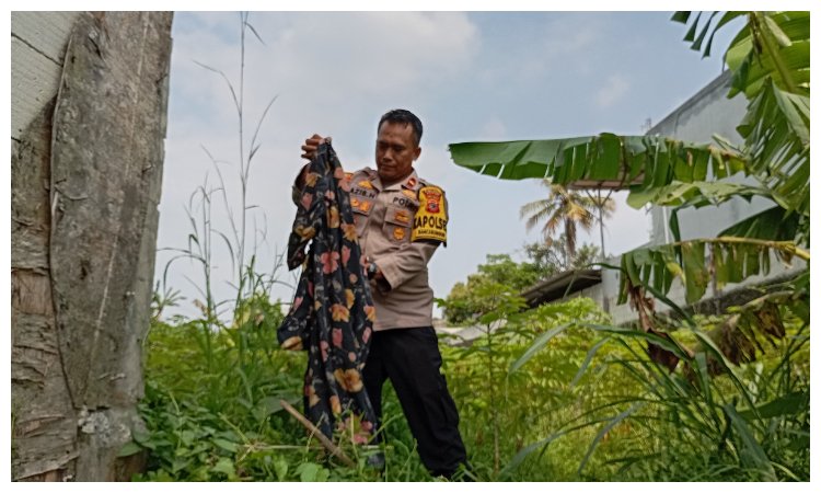 Petugas Polsek Rancabungur menunjukkan barang bukti daster bermotif kembang berwarna hitam sekitar 50 meter dari lokasi penemuan mayat di kebon singkong, desa Rancabungur Kecamatan Rancabungur, Kabupaten Bogor, Kamis 10 Oktober 2024.