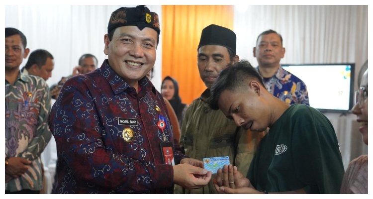 Pj. Bupati Bogor Bachril Bakri memberikan KTP elektronik di sela kunjungan kerjanya di Kecamatan Ciampea didampingi Kadiskominfo Kabupaten Bogor Bayu Ramawanto, Selasa 29 Oktober 2024.